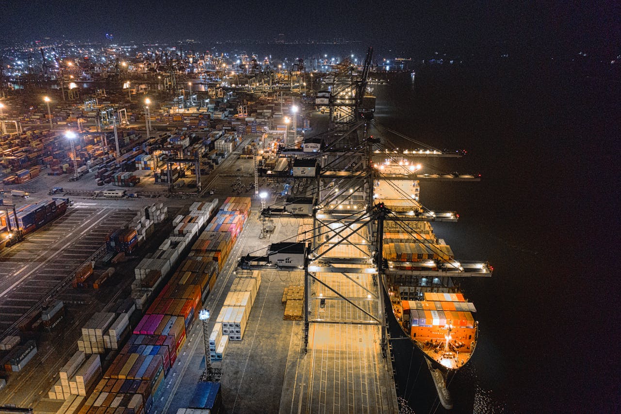 journey A captivating aerial view of Jakarta's bustling shipping port at night, showcasing vibrant activity.