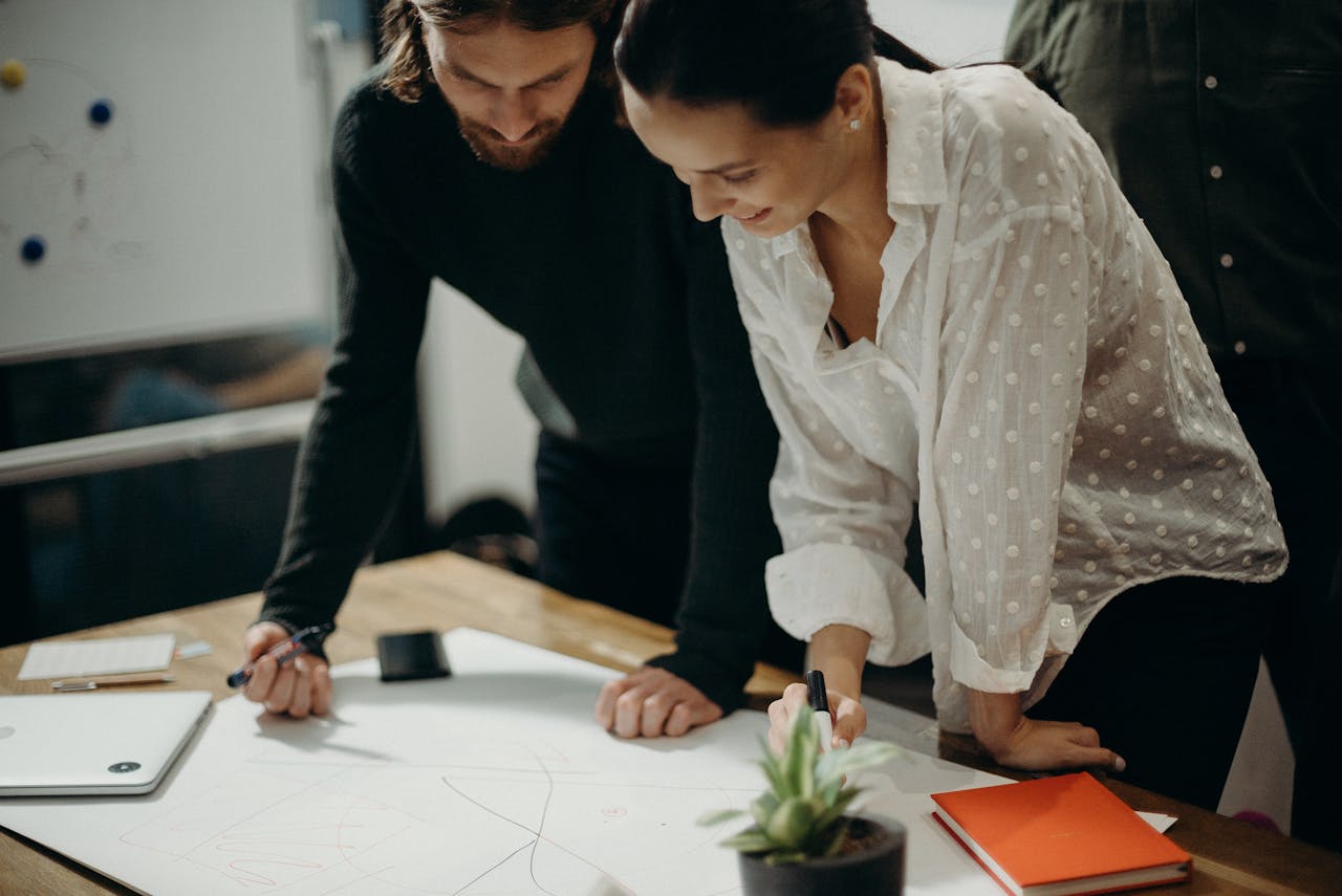 why-choose-us Two colleagues engage in a creative brainstorming session at the office, working together on new ideas.