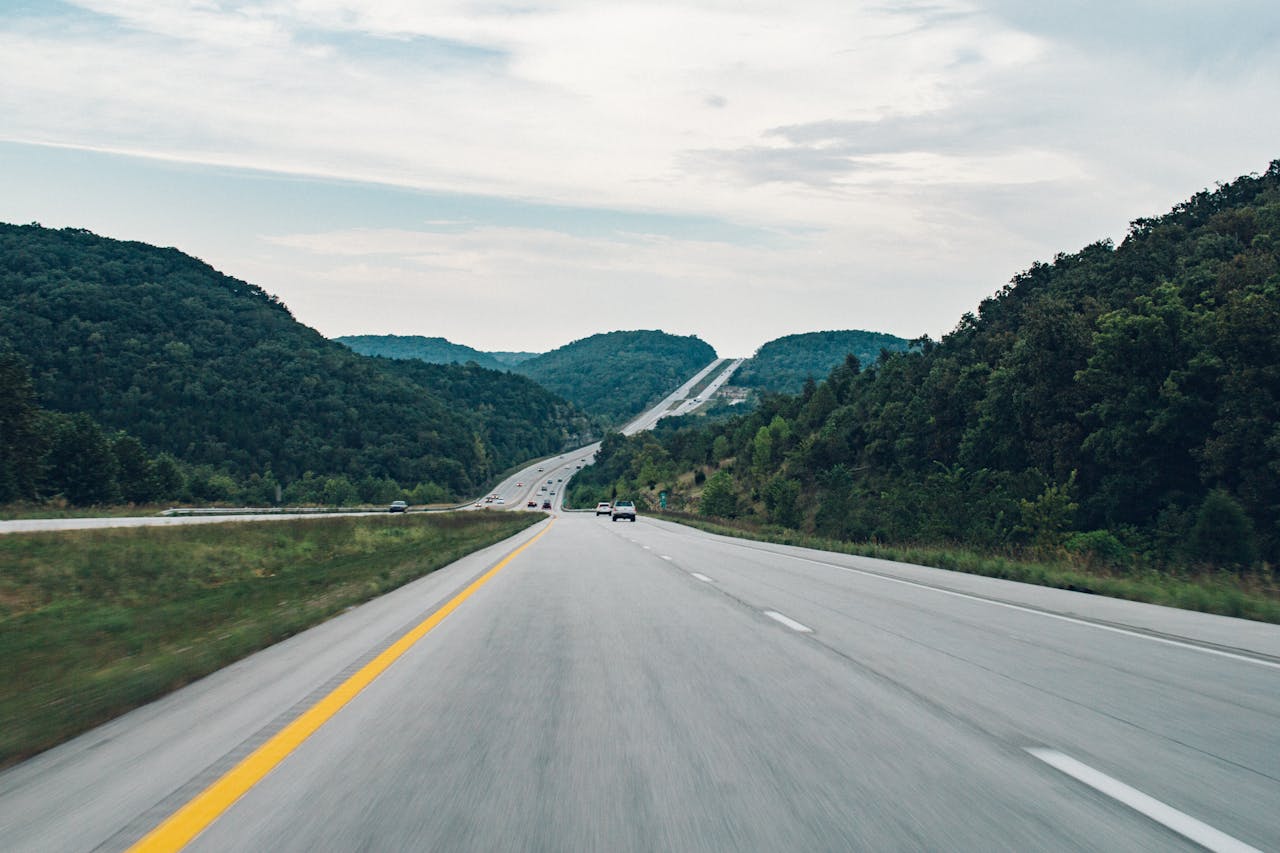 who-we-are A picturesque highway running through lush green hills, ideal for road trips.